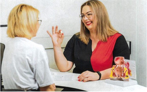 A proctologist doctor shows a rectal suppository to a patient in the hospital during consultation. Diagnosing and treating rectal bleeding.